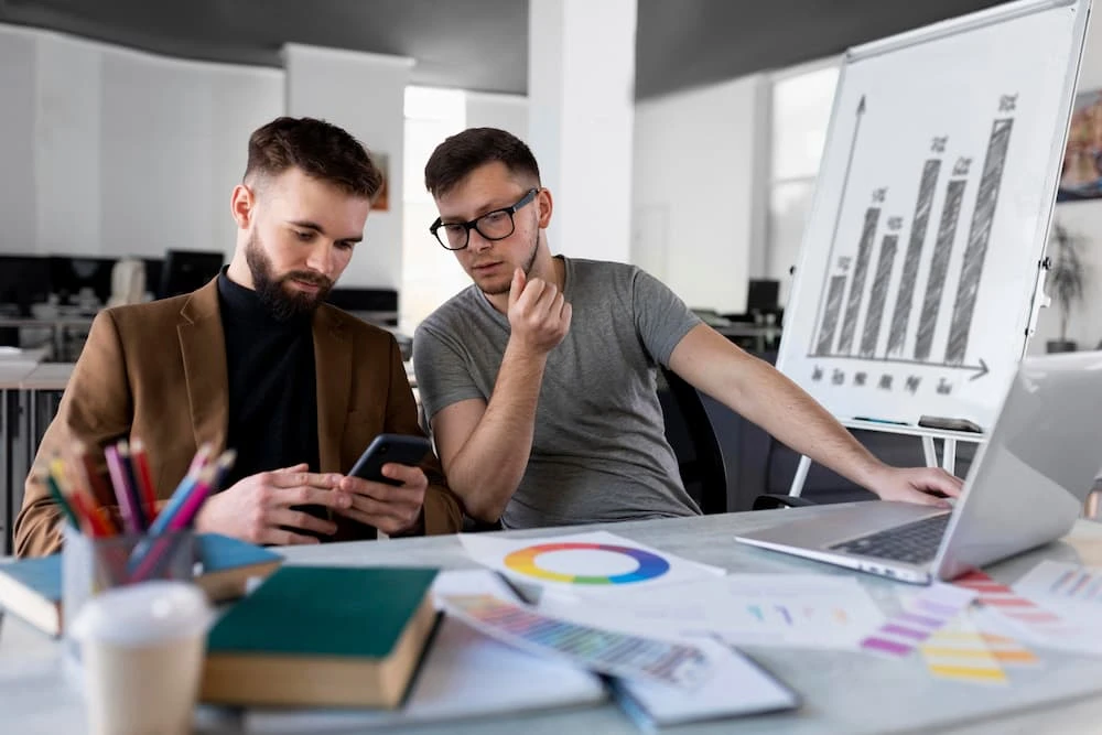 Homens analisando um gráfico juntos no trabalho