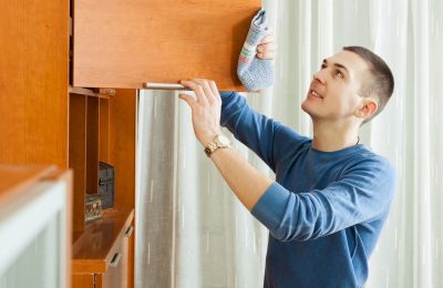 Man cleaning wooden furniture