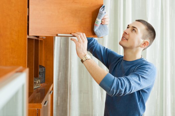 Man cleaning wooden furniture