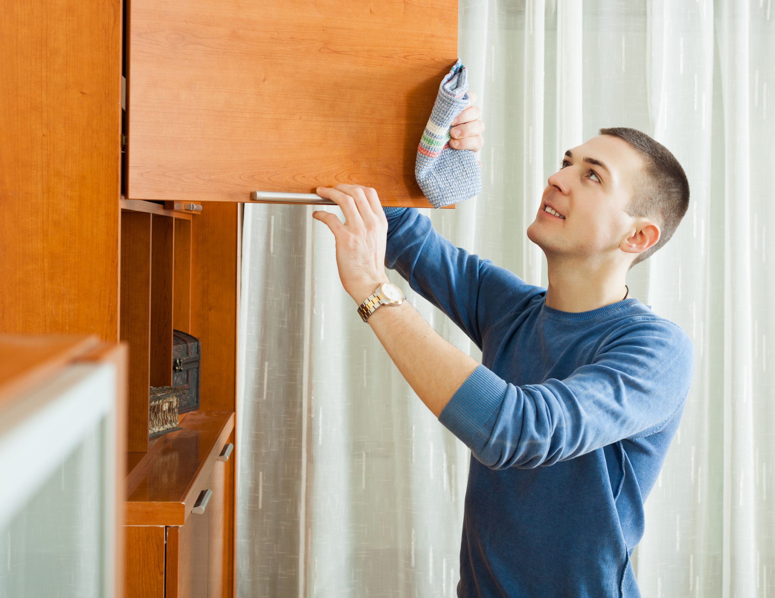 Man cleaning wooden furniture
